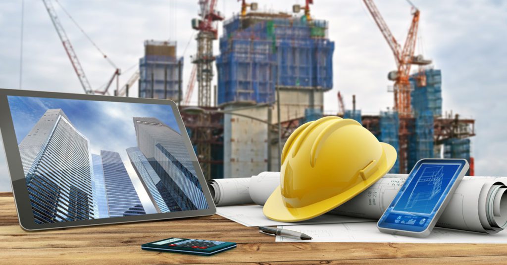 blueprints and safety helmet over a table in construction site