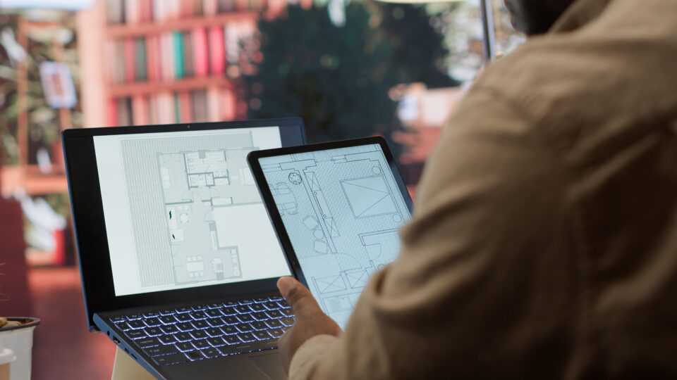 Entrepreneur Planning An Office Relocation Evaluating Architectural Blueprints