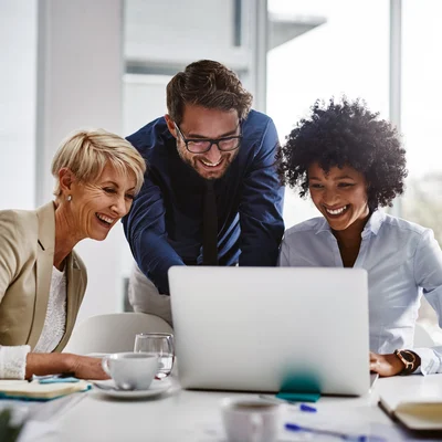 Three Coworkers Surrounding Laptop