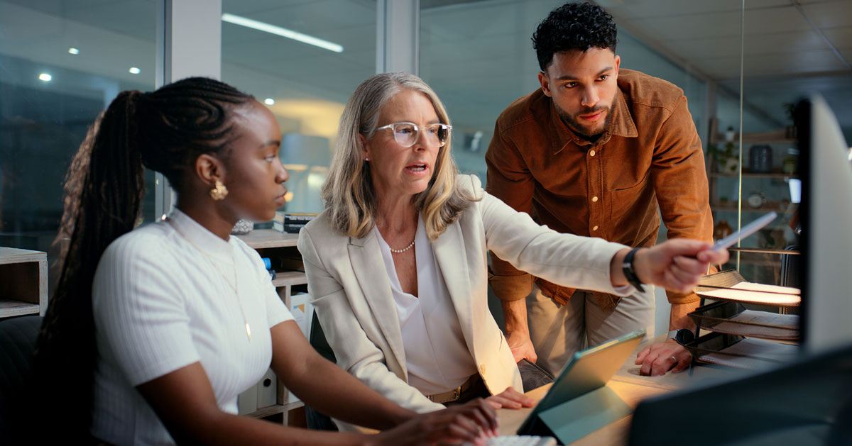 Three Coworkers Viewing Grants On Computer Blog