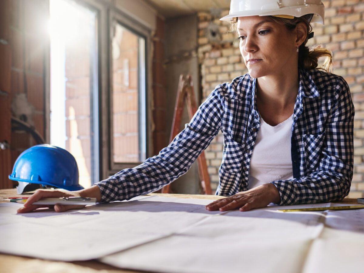 Woman Reviewing Plans At Table